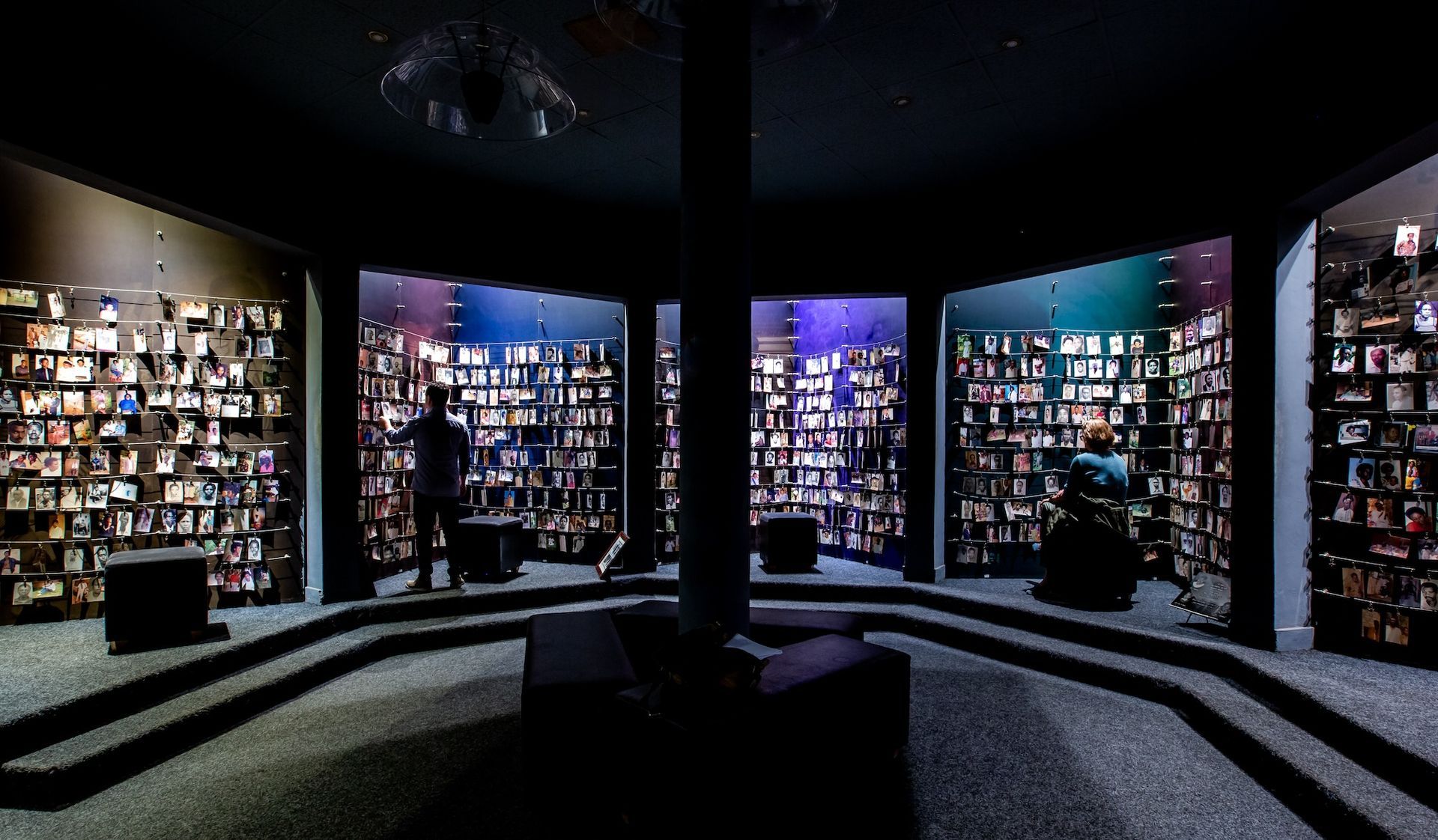 A man is standing in a room with a lot of bookshelves.