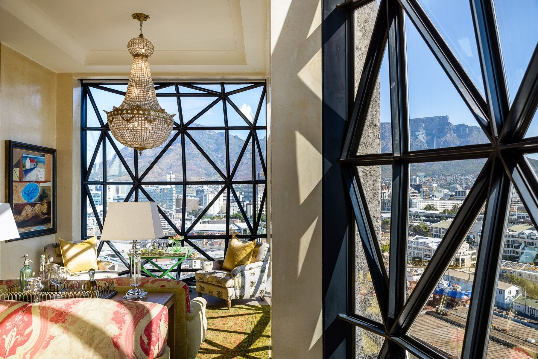 A living room with a large window and a chandelier hanging from the ceiling.