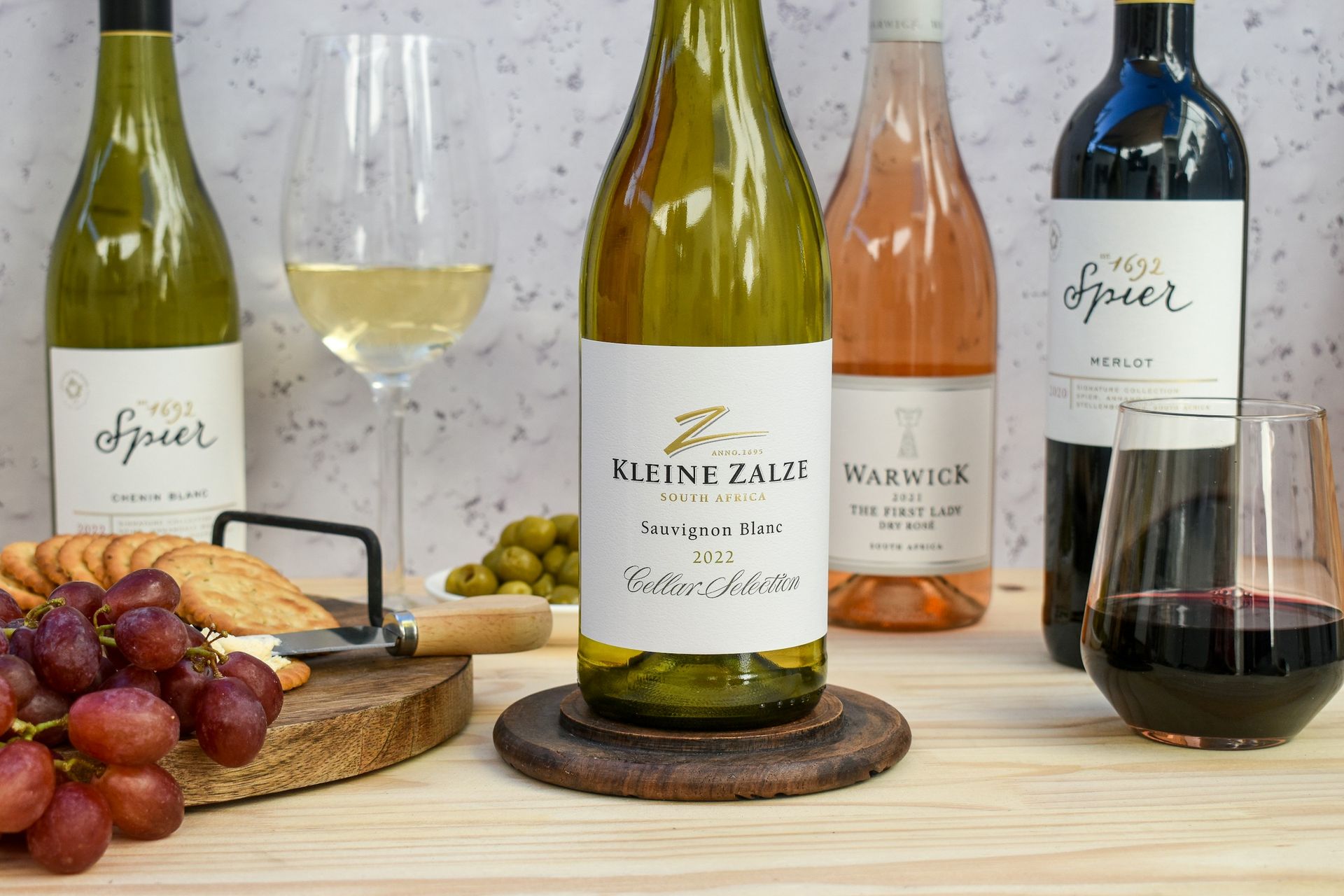 Four bottles of wine are sitting on a wooden table.