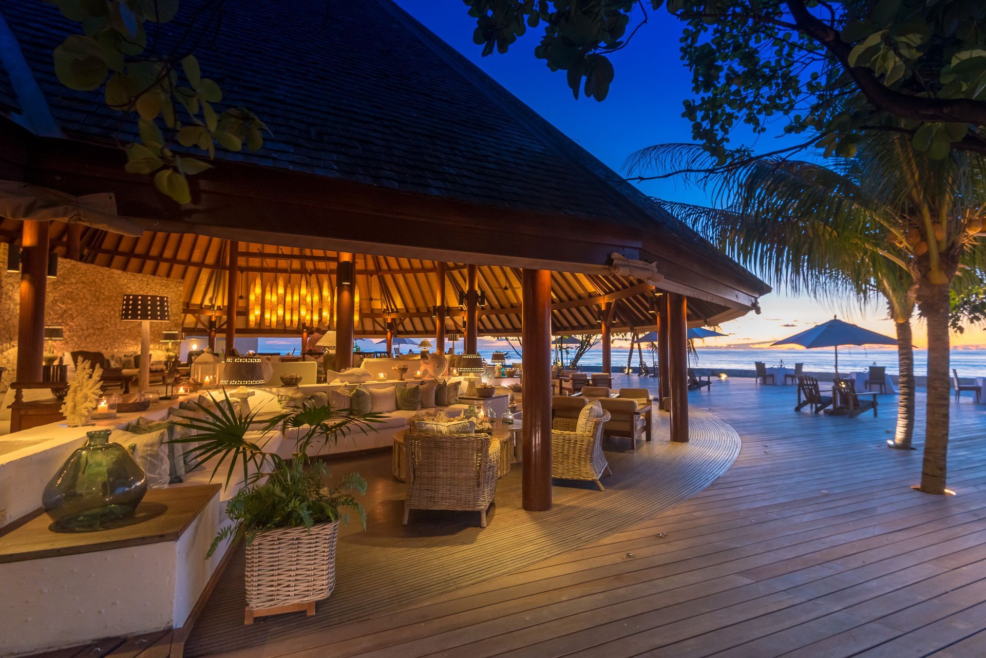 There is a restaurant on the beach with a lot of chairs and umbrellas.