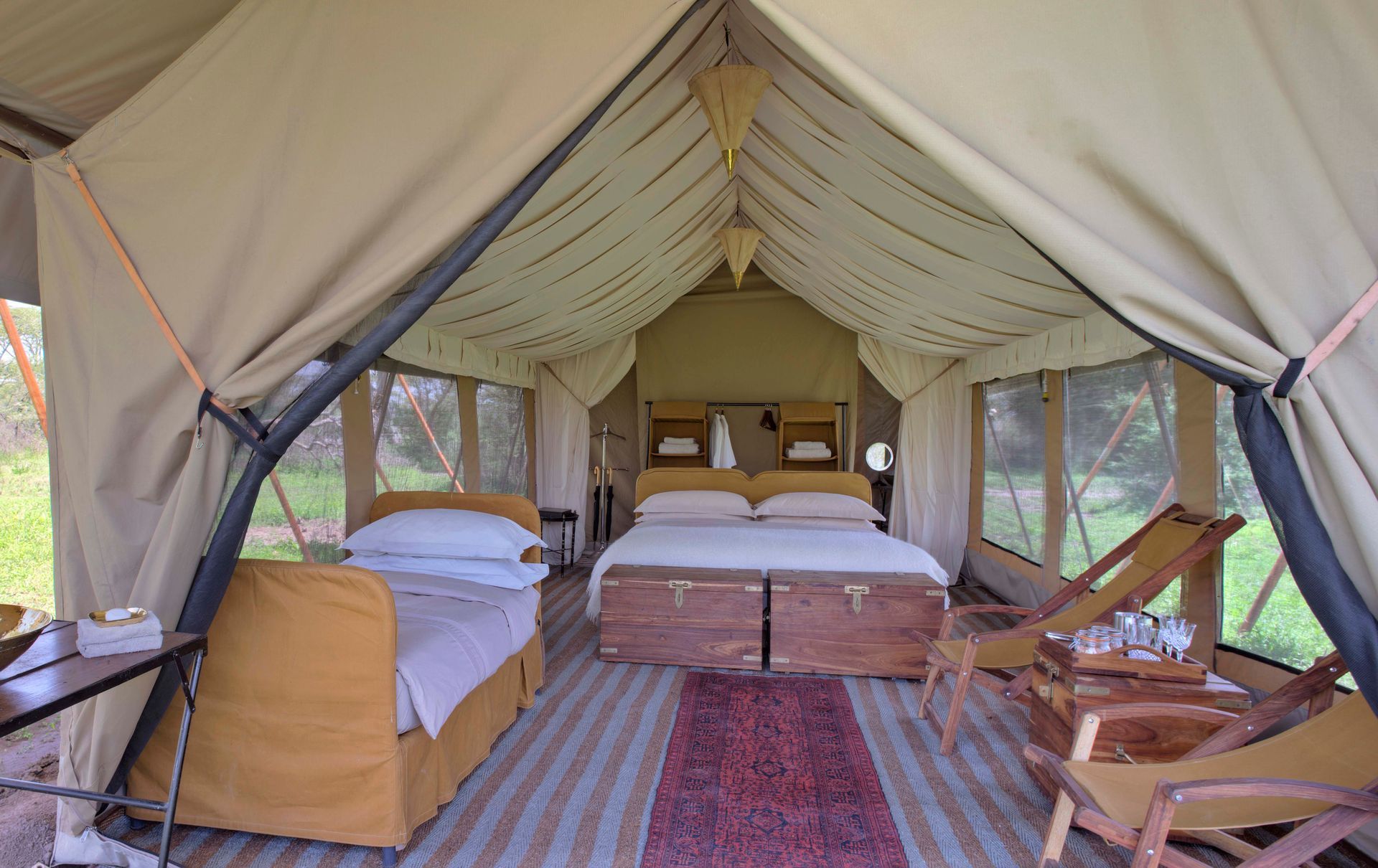 A tent with a bed and chairs inside of it