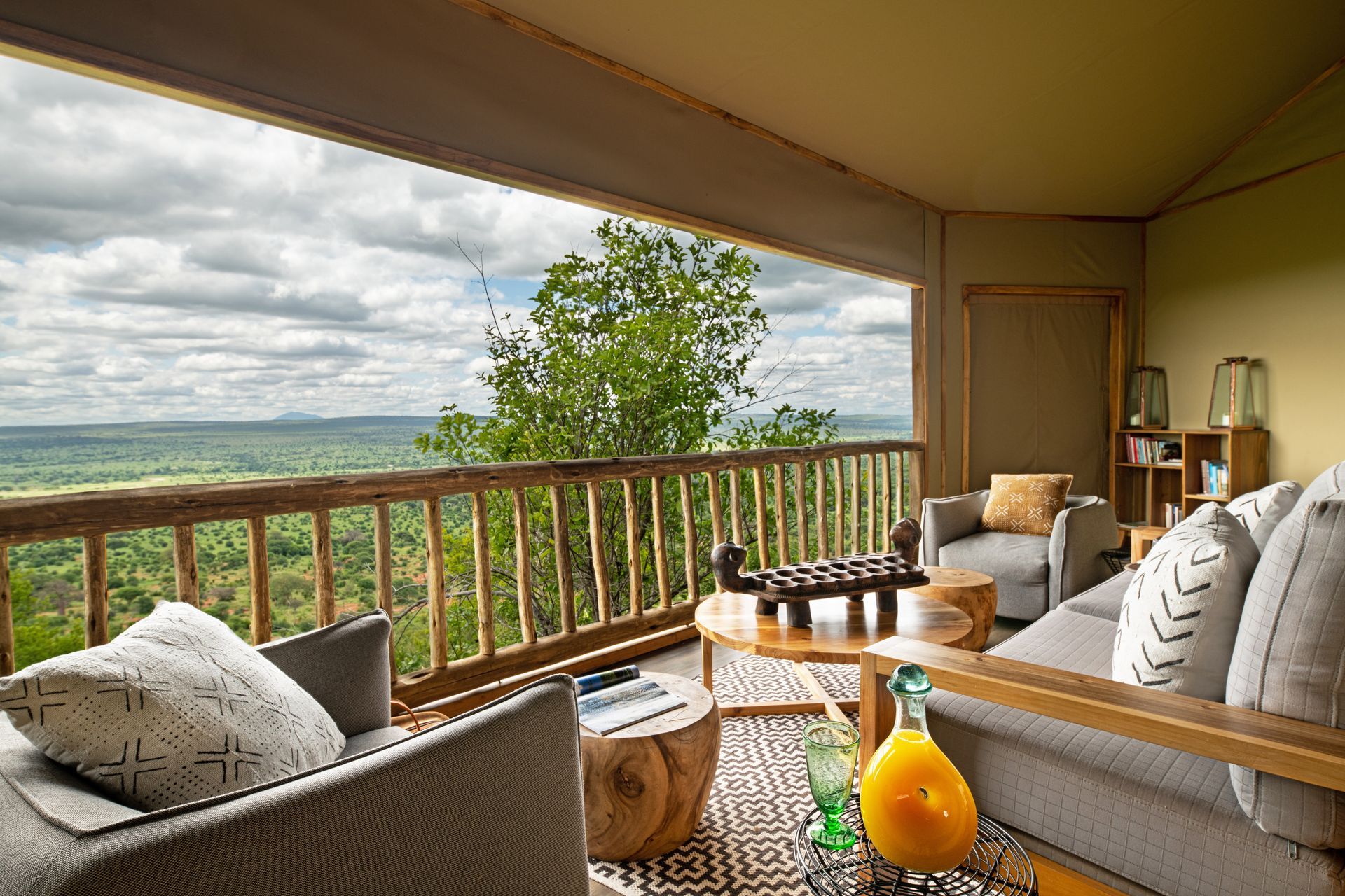 A living room with a couch , chairs and a table with a view of the landscape.