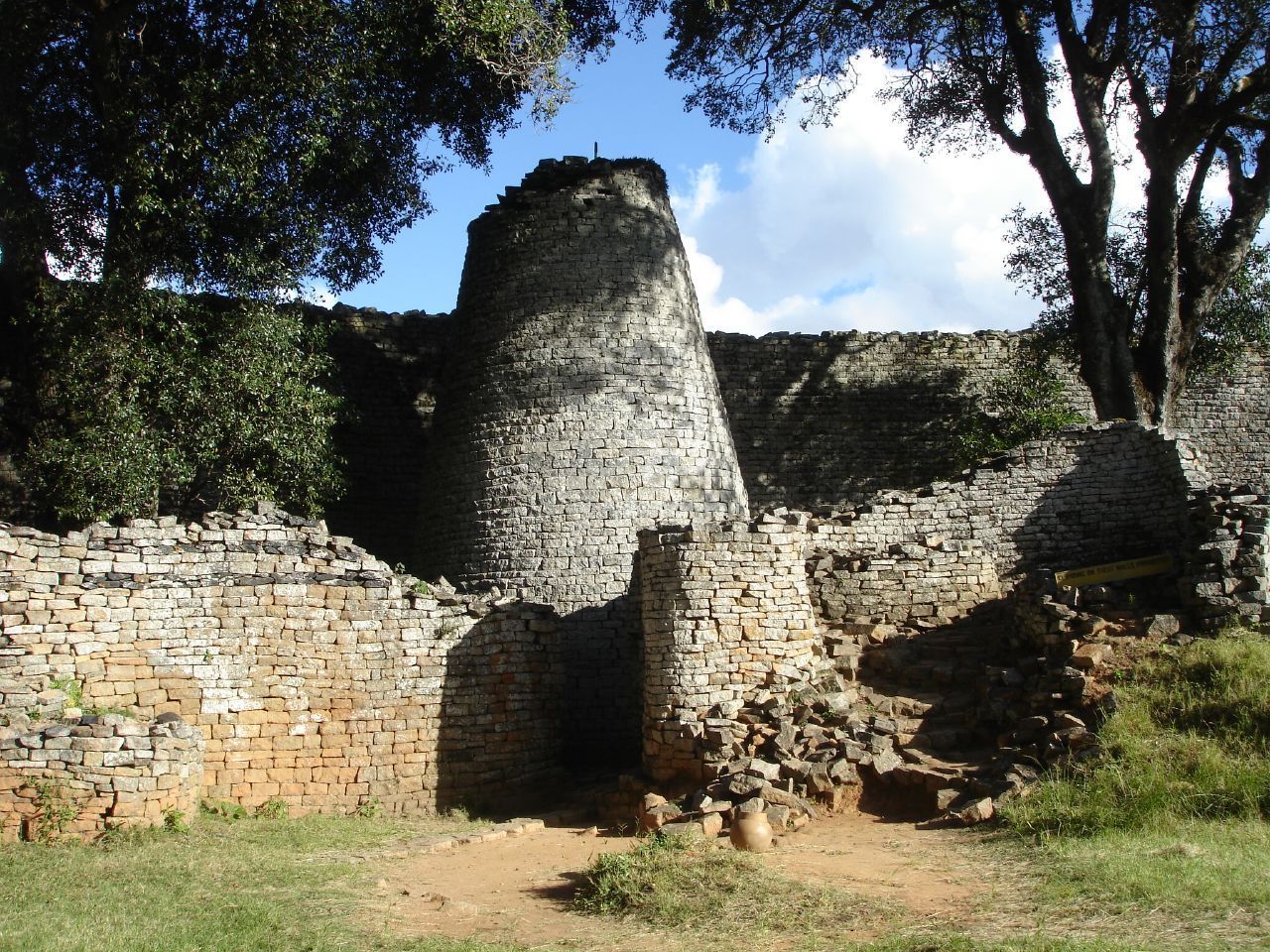 A brick wall with a tree in the foreground