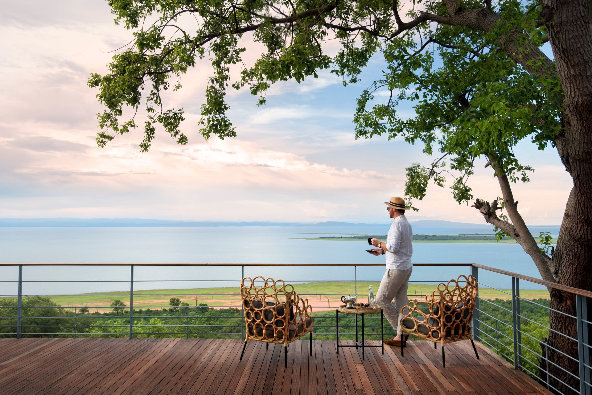 A man is standing on a deck overlooking a lake.