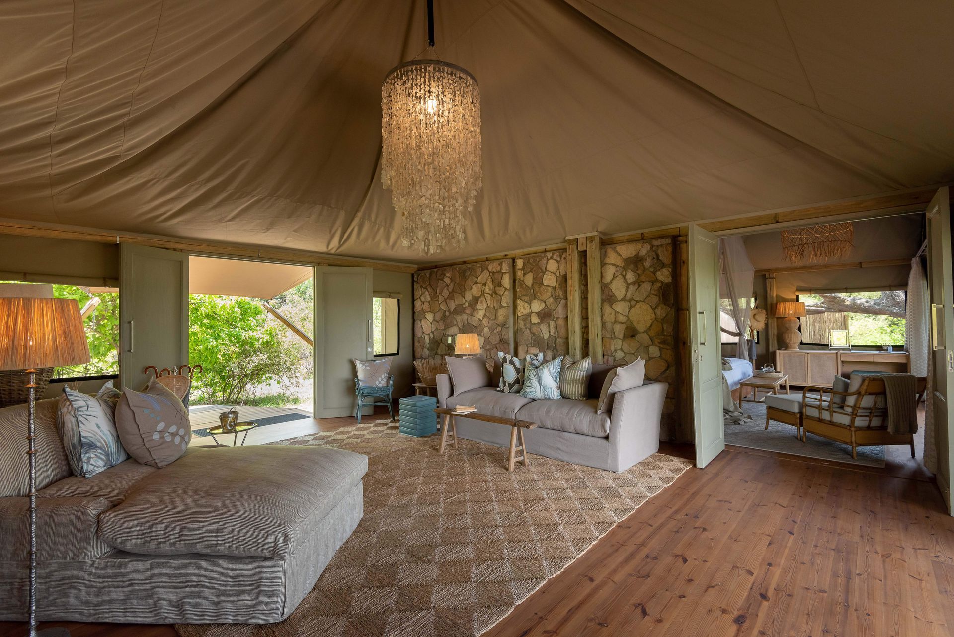 A living room in a tent with a chandelier hanging from the ceiling.