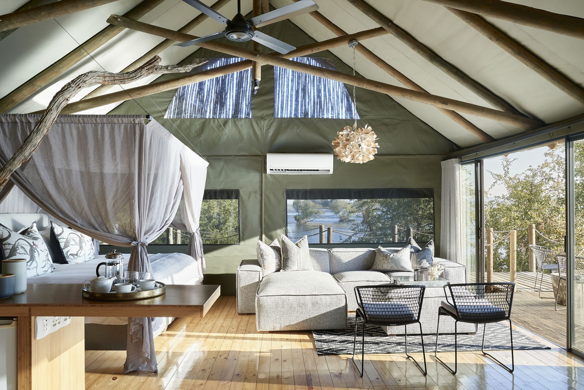 A living room with a canopy bed , couch , table and chairs.