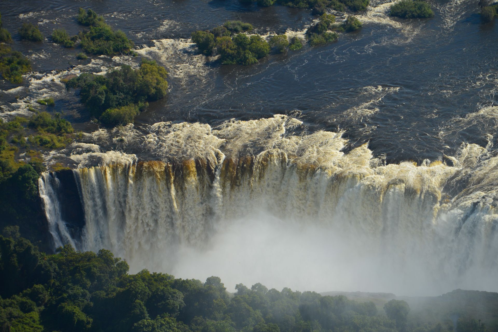 An aerial view of a waterfall in the middle of a forest