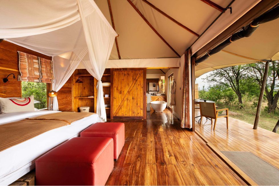 A bedroom with a canopy bed and wooden floors