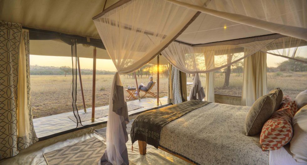 A bedroom with a canopy bed and a view of a field.