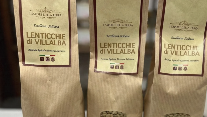 Three brown paper bags labeled “Lenticchie di Villalba” on a shelf