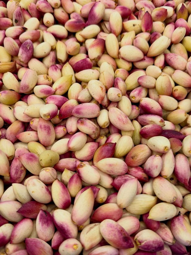 Pile of shelled pistachios with pink and beige skins