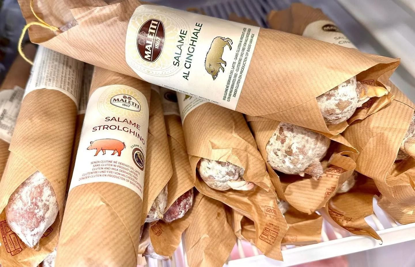 Basket of wrapped artisanal loaves with black labels on a market display