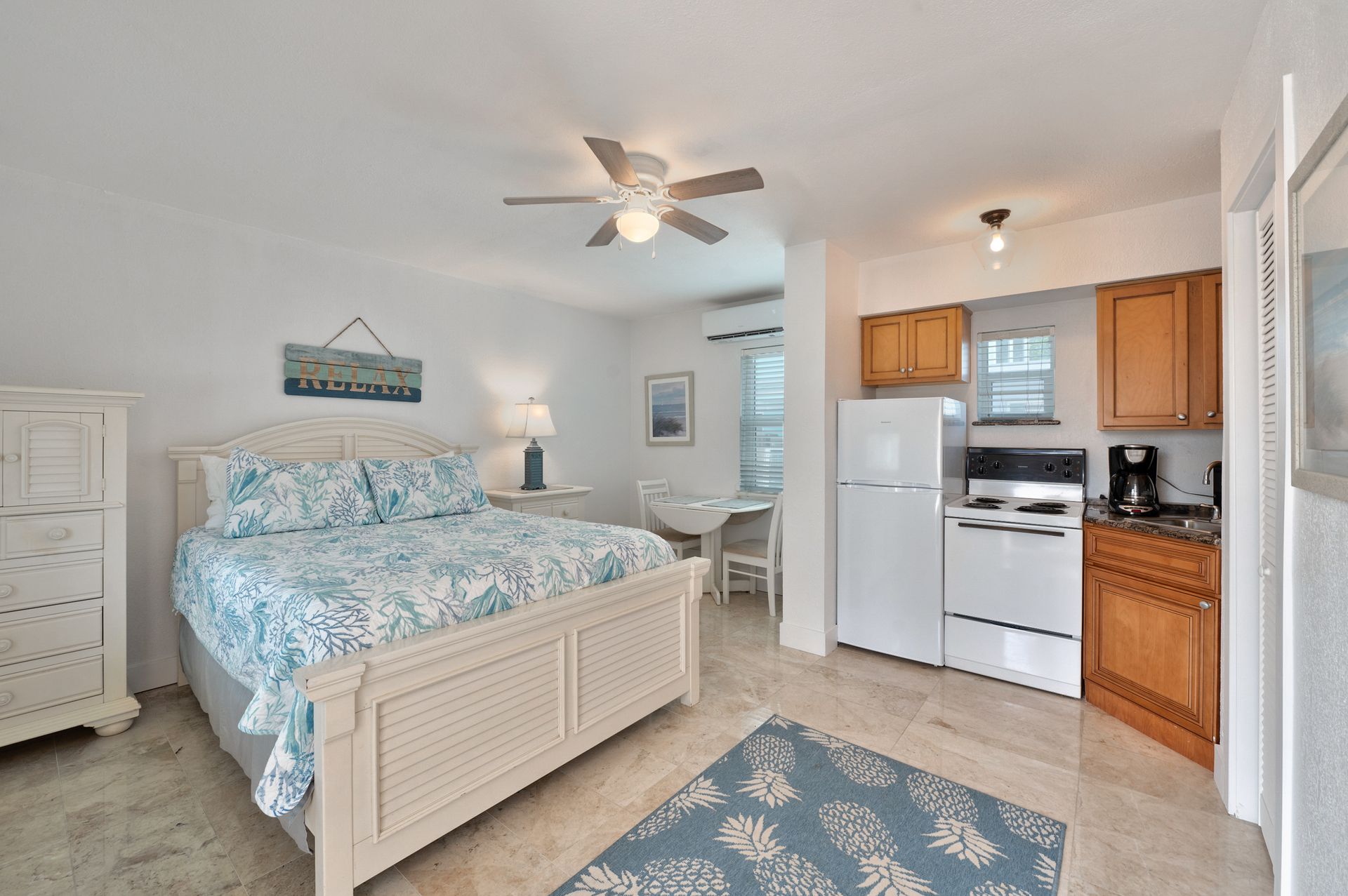 Studio apartment with a bed, small kitchen, and dining area; light and airy.
