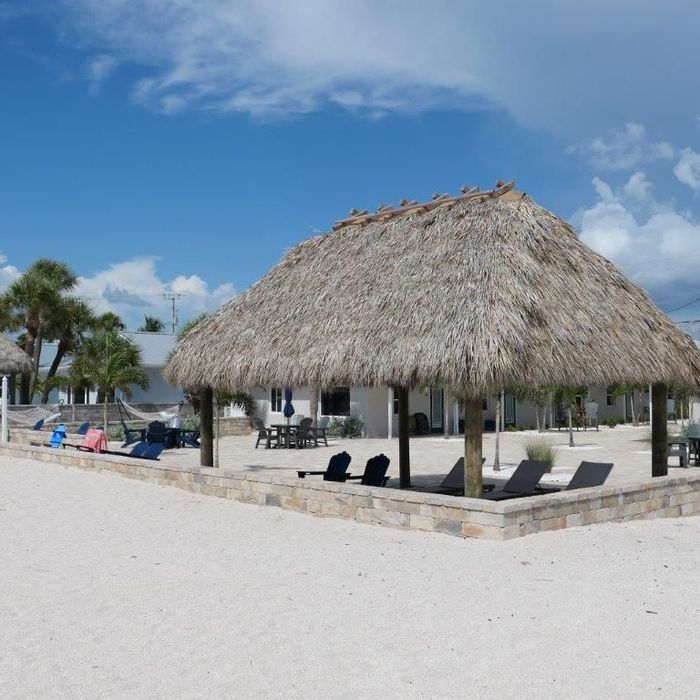 Thatched beach cabana on a white sand resort beach under a blue sky