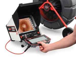 A person is holding a tablet in front of a drain camera