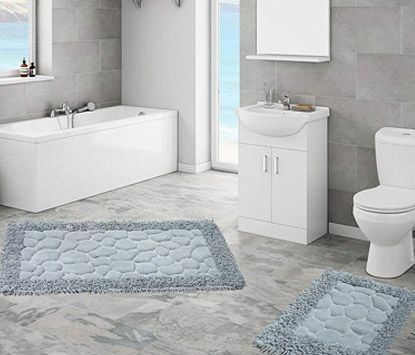 A bathroom with a bathtub , toilet , sink and rug.