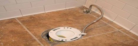A toilet seat with a hose attached to it in a bathroom.