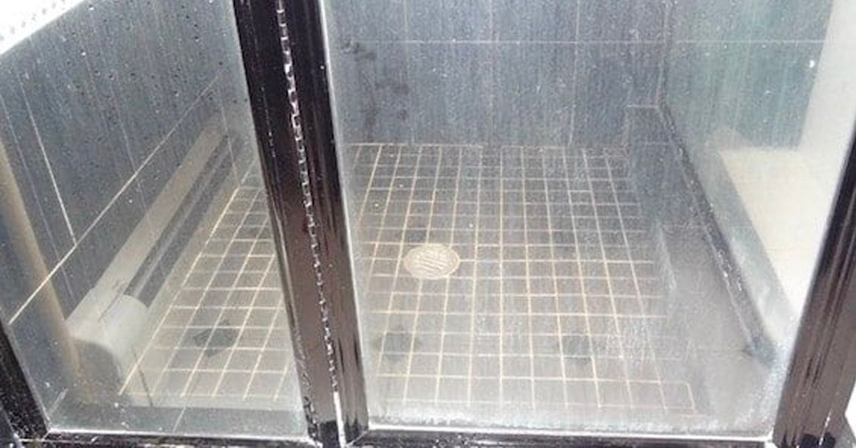 A shower stall with a tiled floor and a glass door.