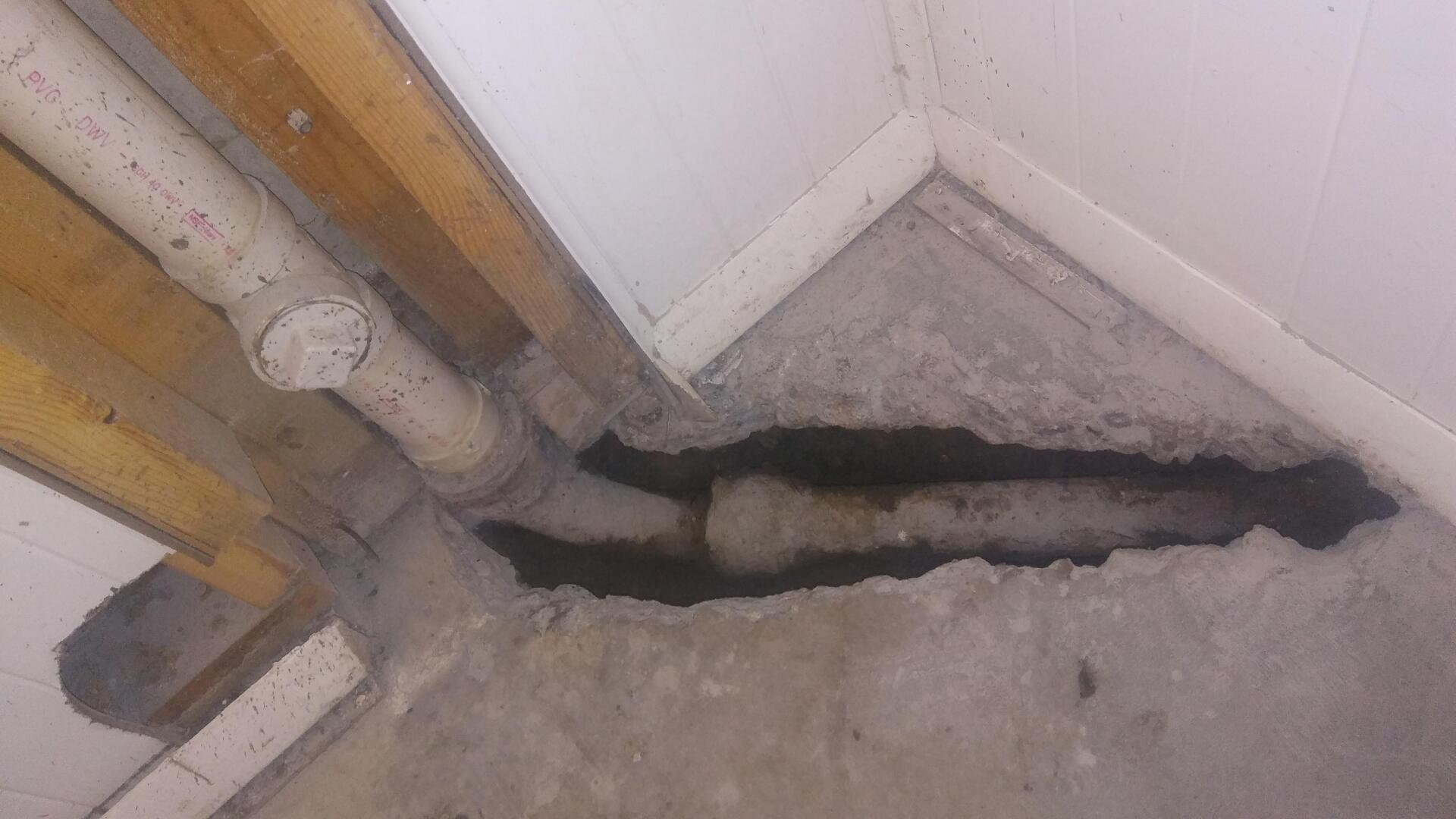 There is a hole in the floor in the corner of a room.