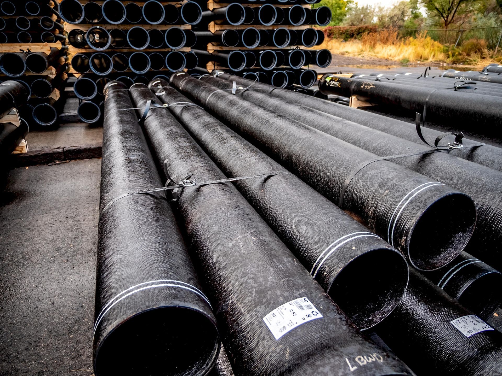 A bunch of black pipes are stacked on top of each other.