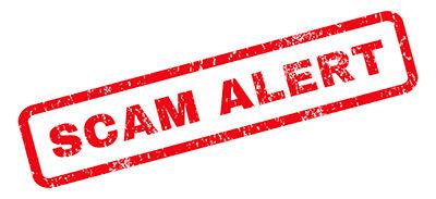 A red stamp that says scam alert on a white background.