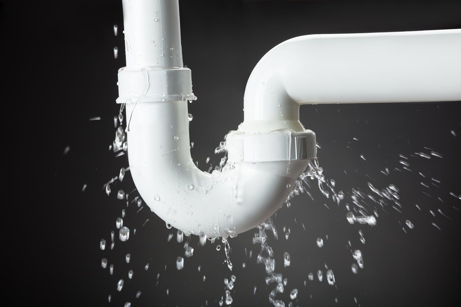 A white pipe is leaking water on a black background
