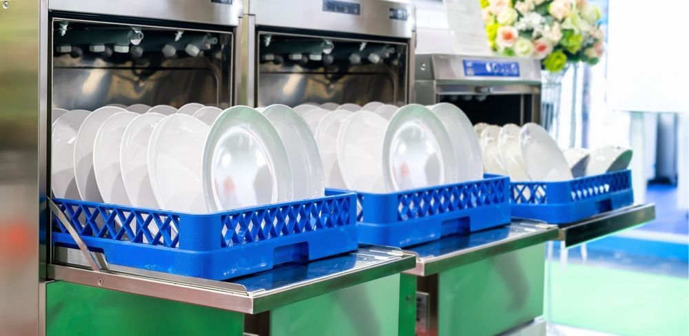 A dishwasher filled with plates and cups in a kitchen.