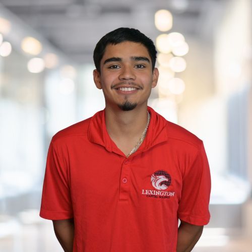 Young man in a red polo shirt smiles at the camera, with 