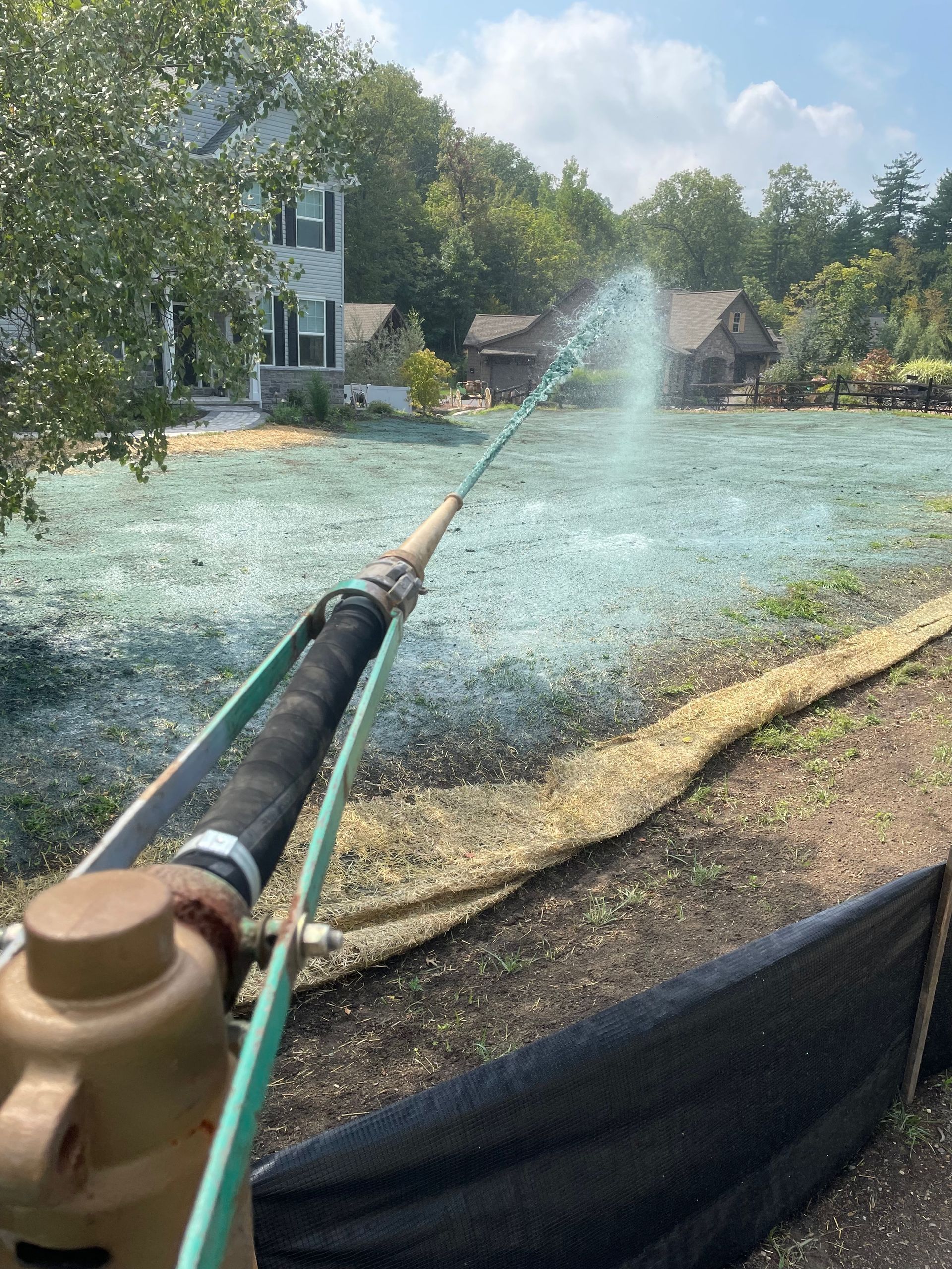 A person is spraying a field with a hose.