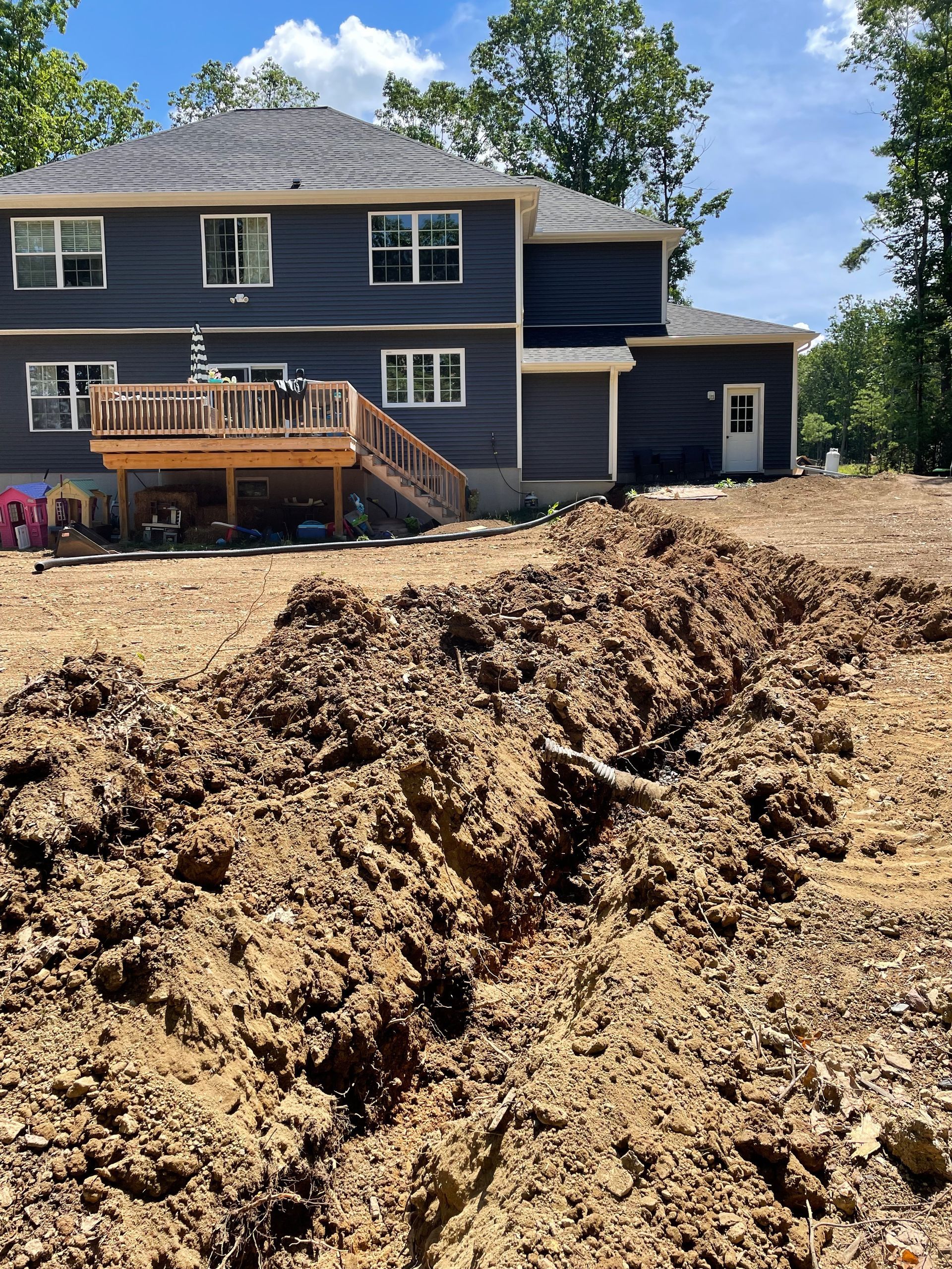 A large pile of dirt is in front of a house