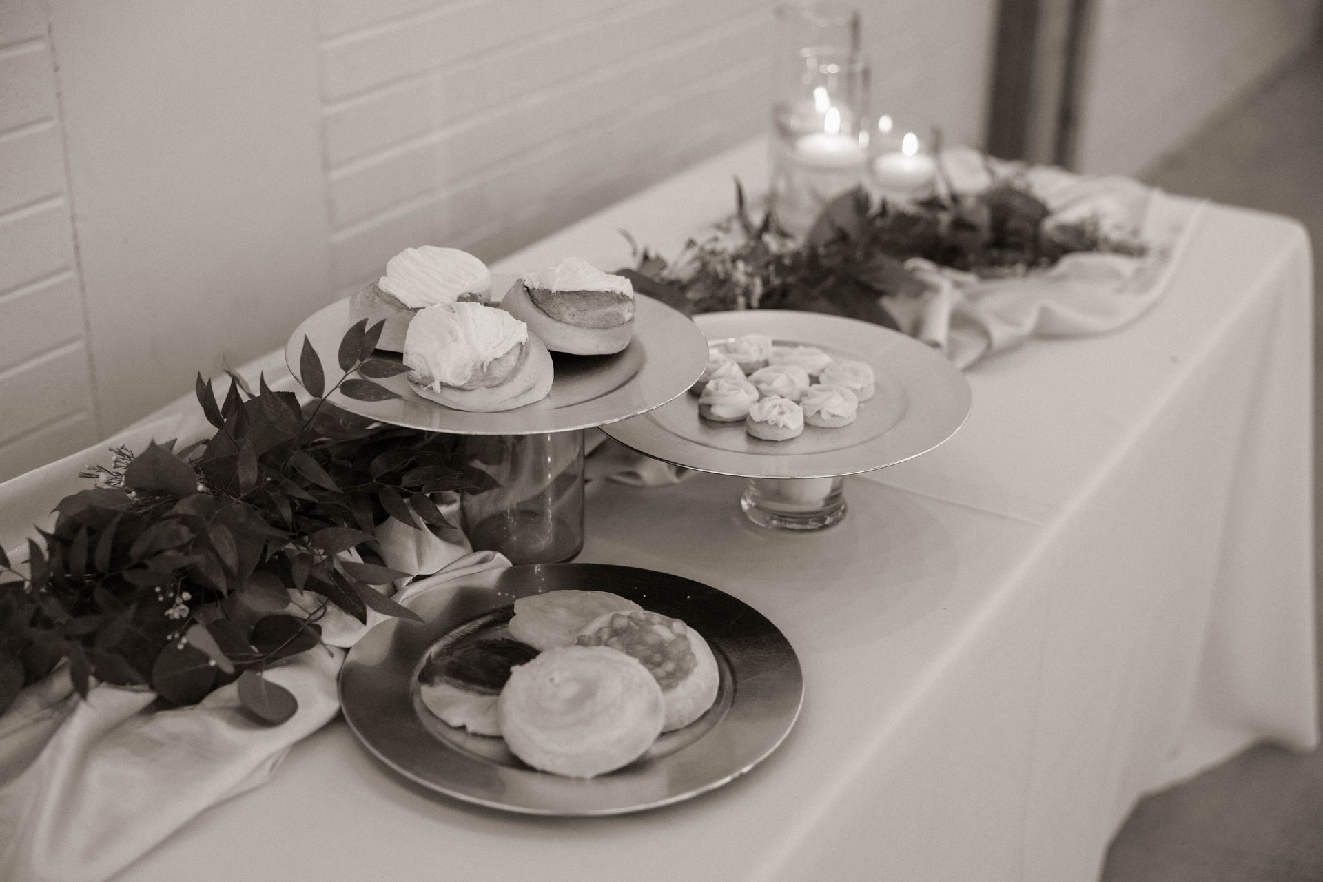A table set for a wedding reception with plates , glasses , and flowers.