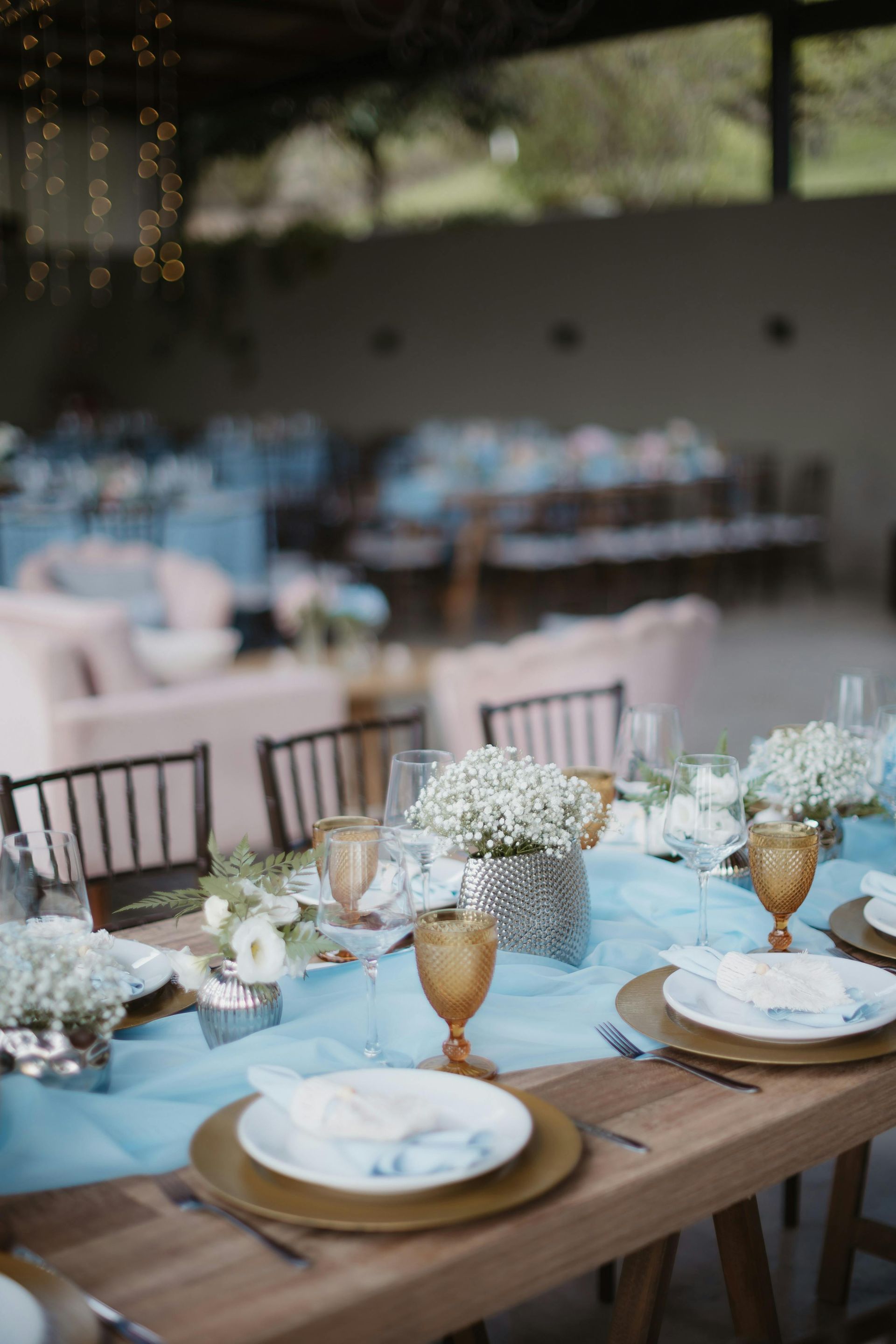 A table set for a wedding reception with plates , glasses , and flowers.