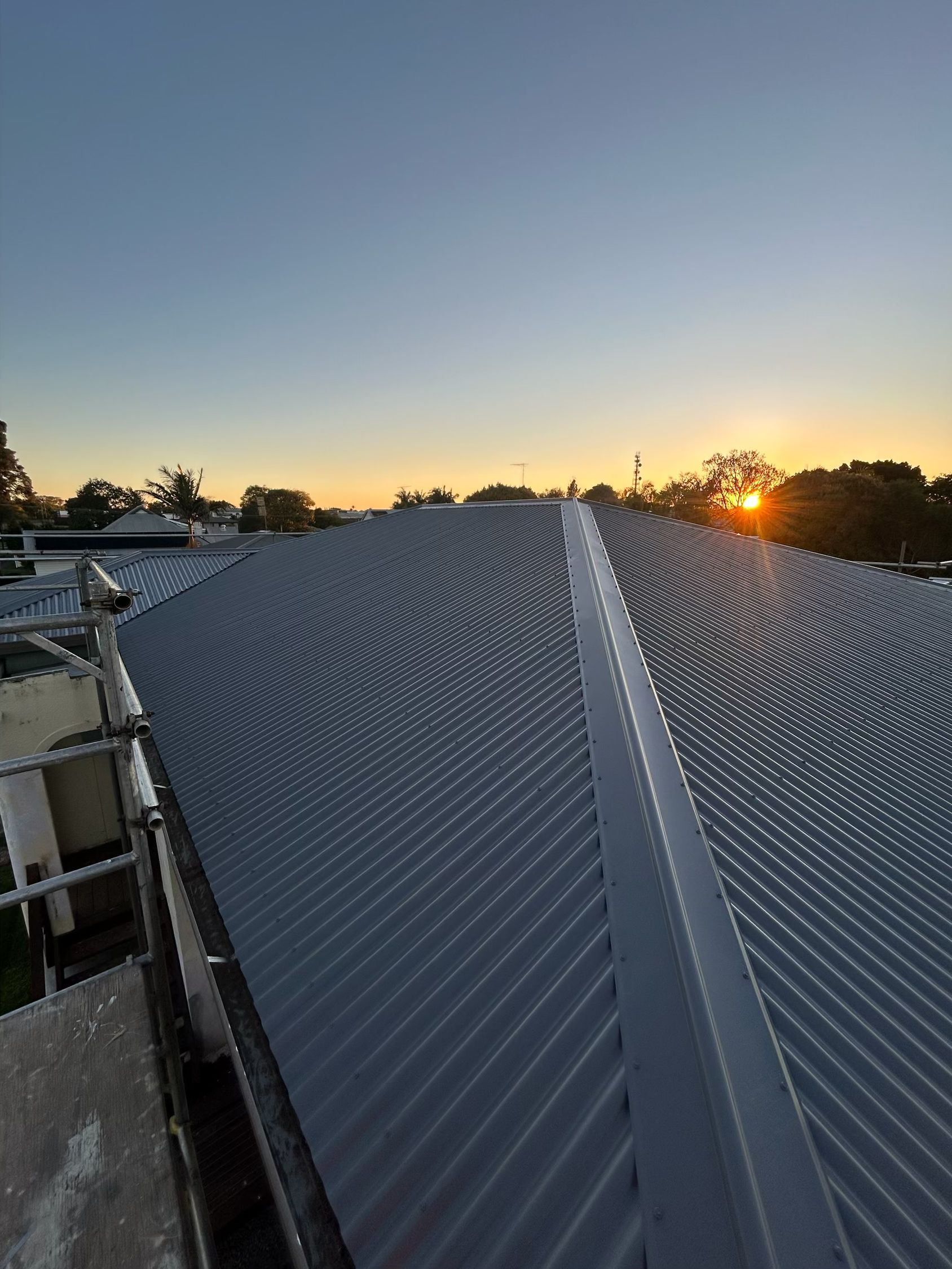 Metal roof with a sunrise in the background— Eli Mcauley Constructions in Grafton, NSW