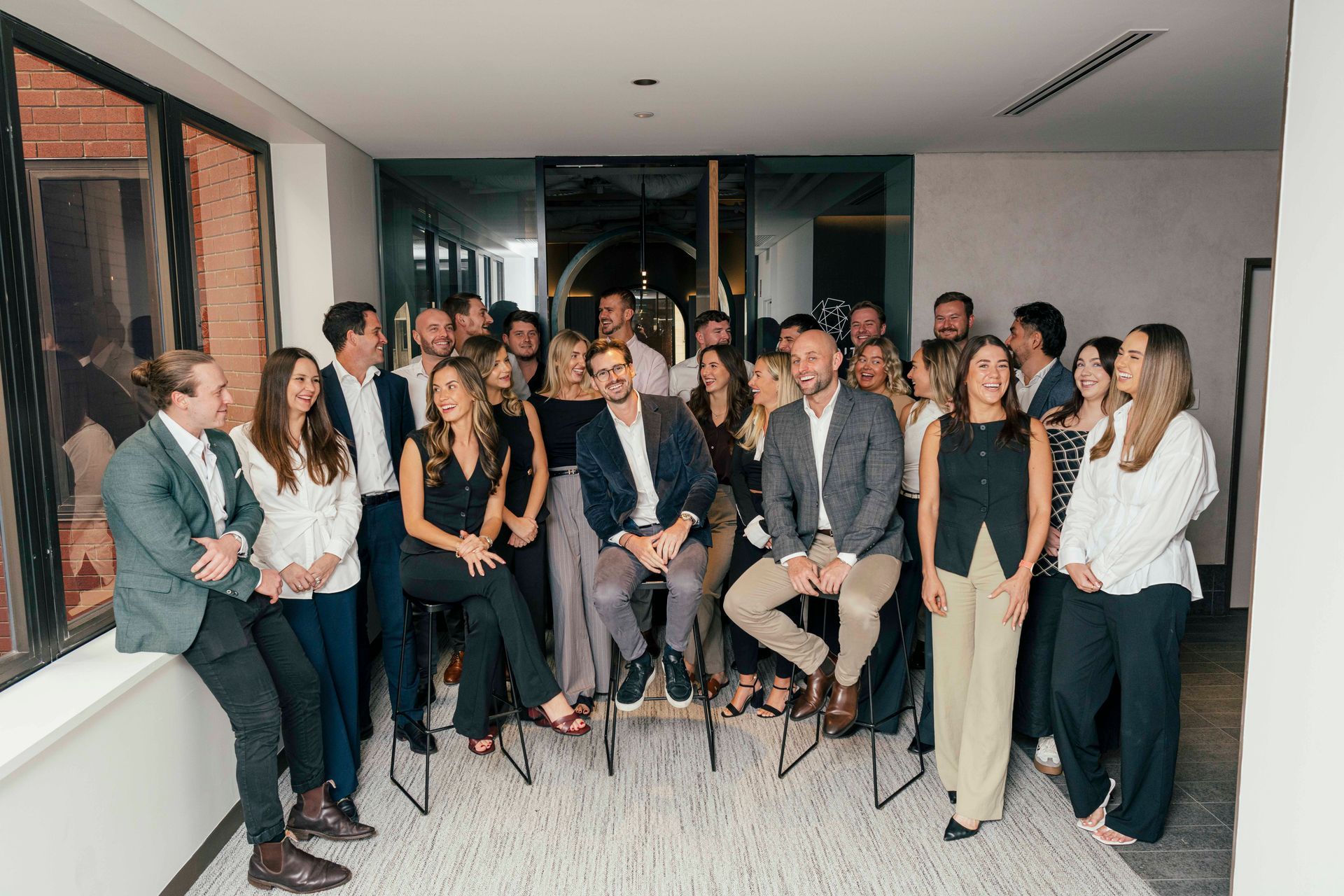 Group of people posing indoors in formal attire at a business event