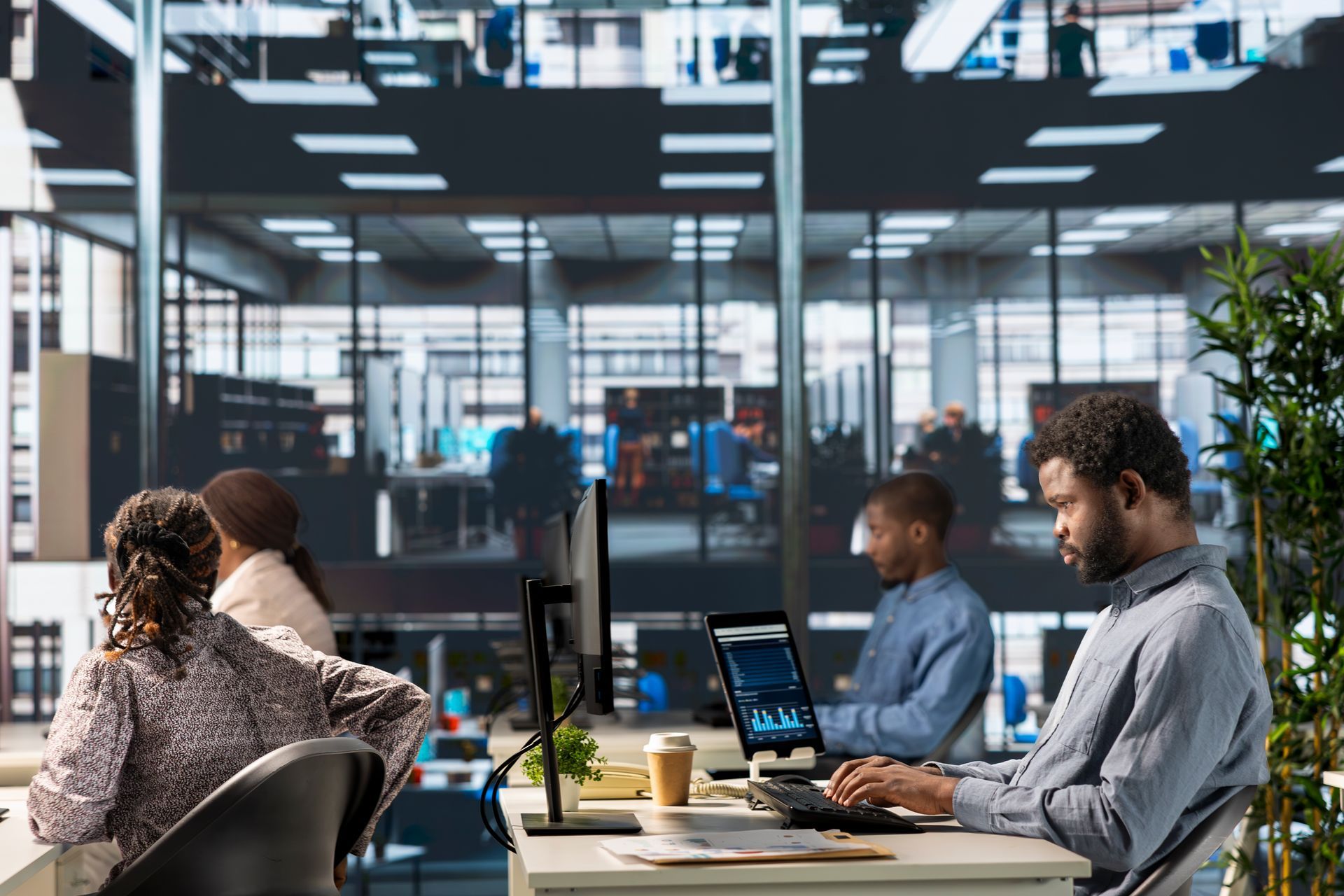 Office team working at desks in a glass-walled modern workspace