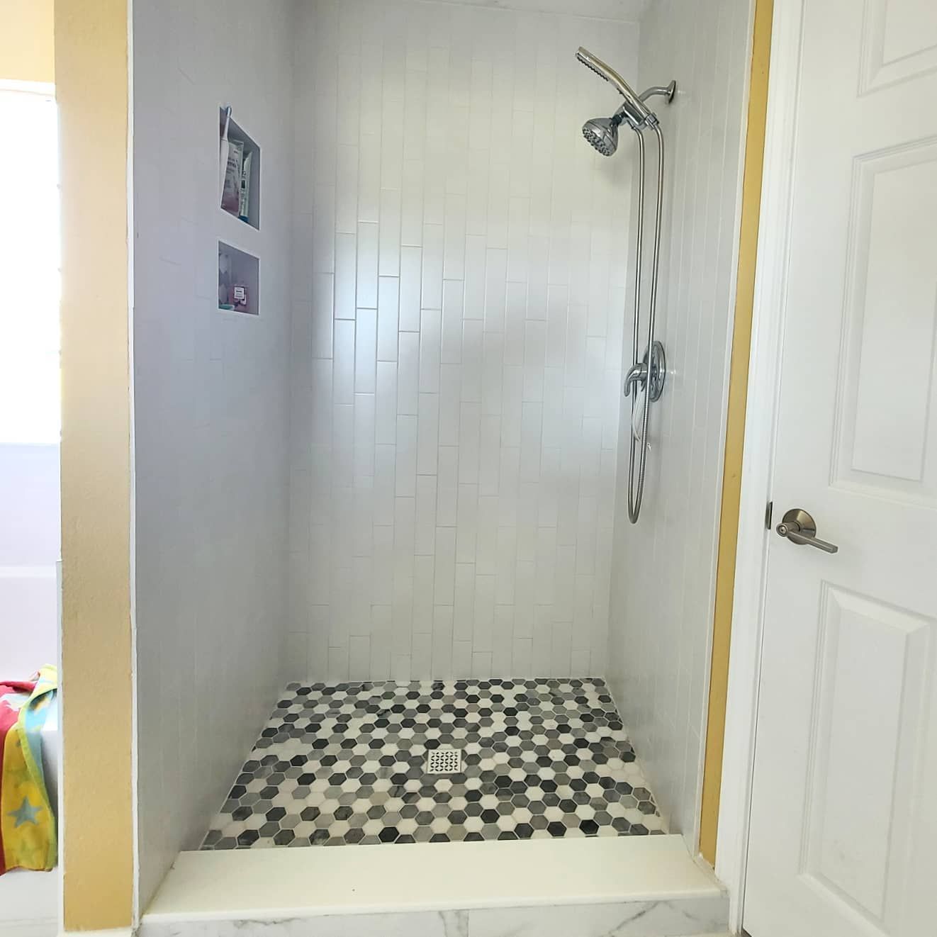 A shower with a tiled floor and a shower head