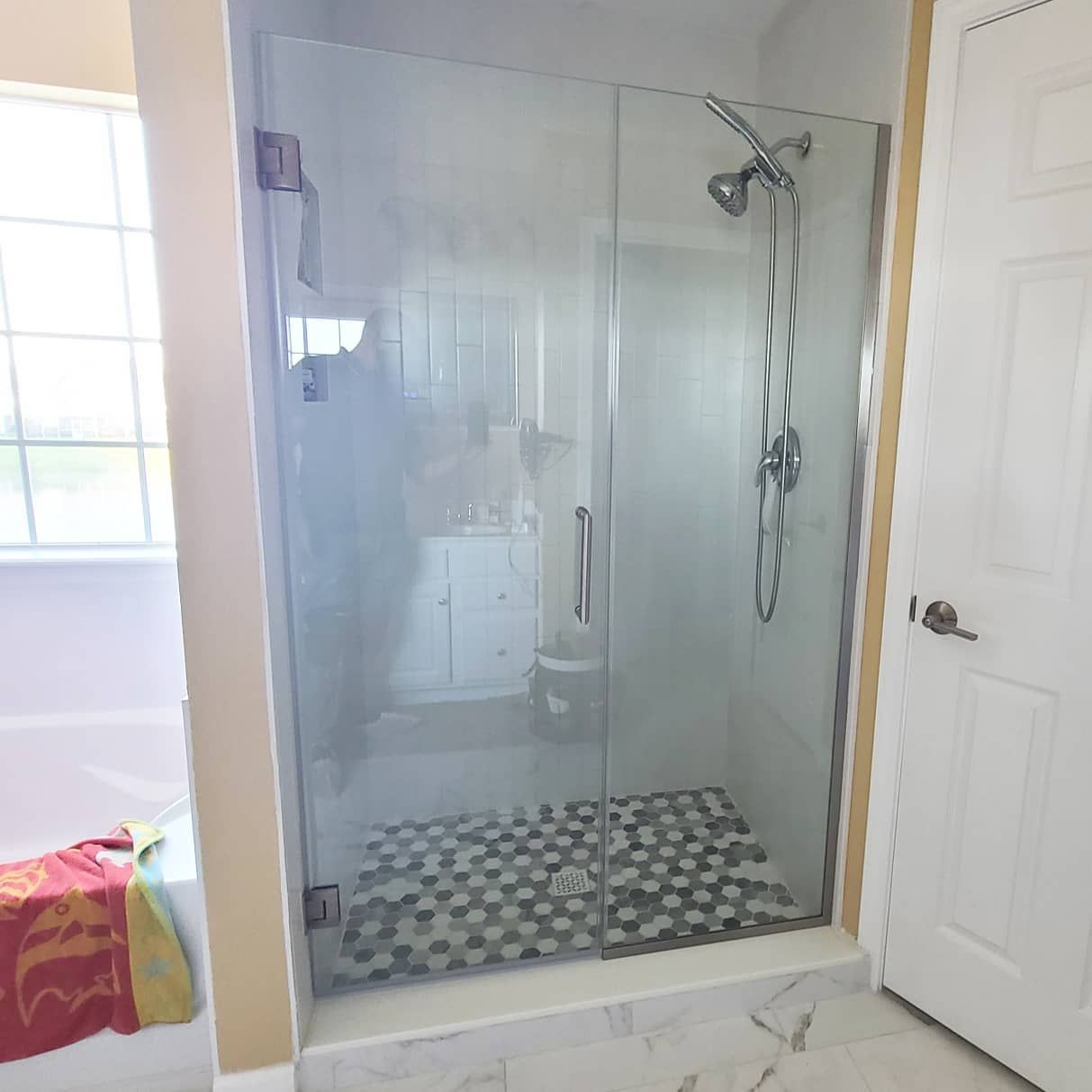 A bathroom with a walk in shower with a glass door