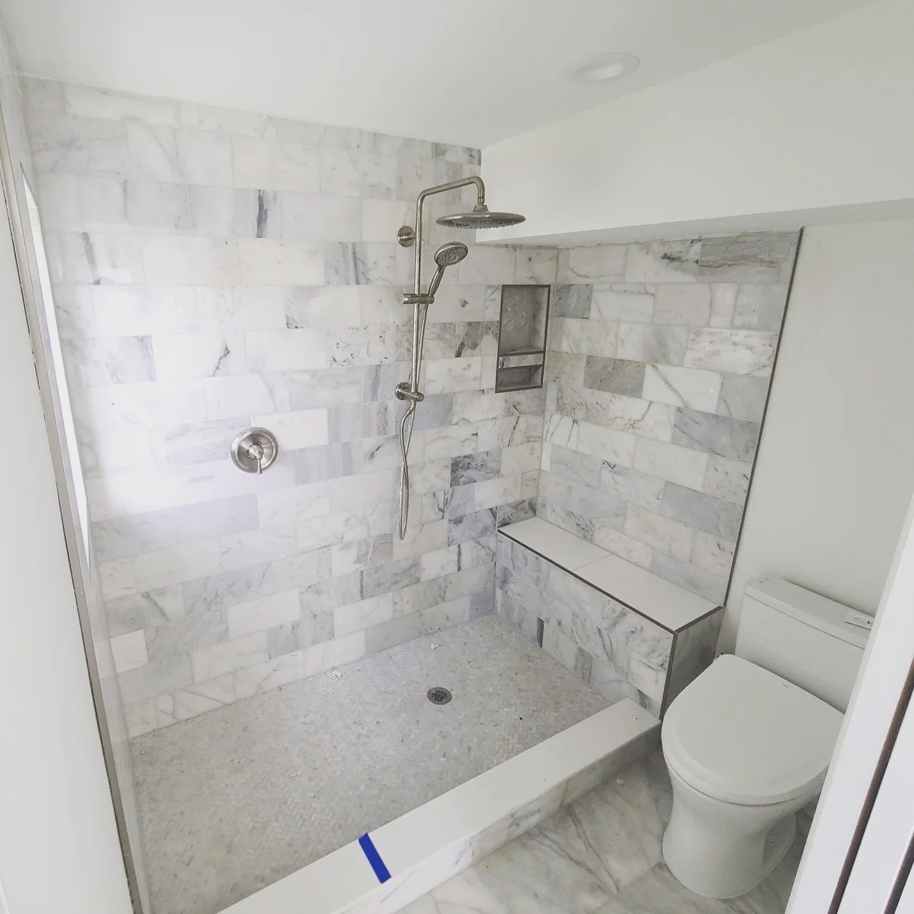 A bathroom with a walk in shower and a toilet
