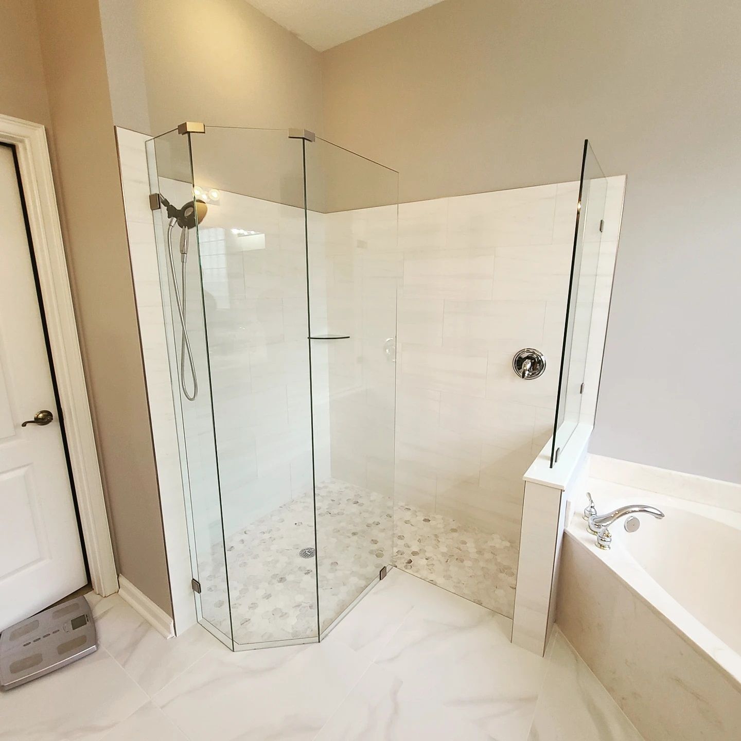 A bathroom with a walk in shower and a bathtub.