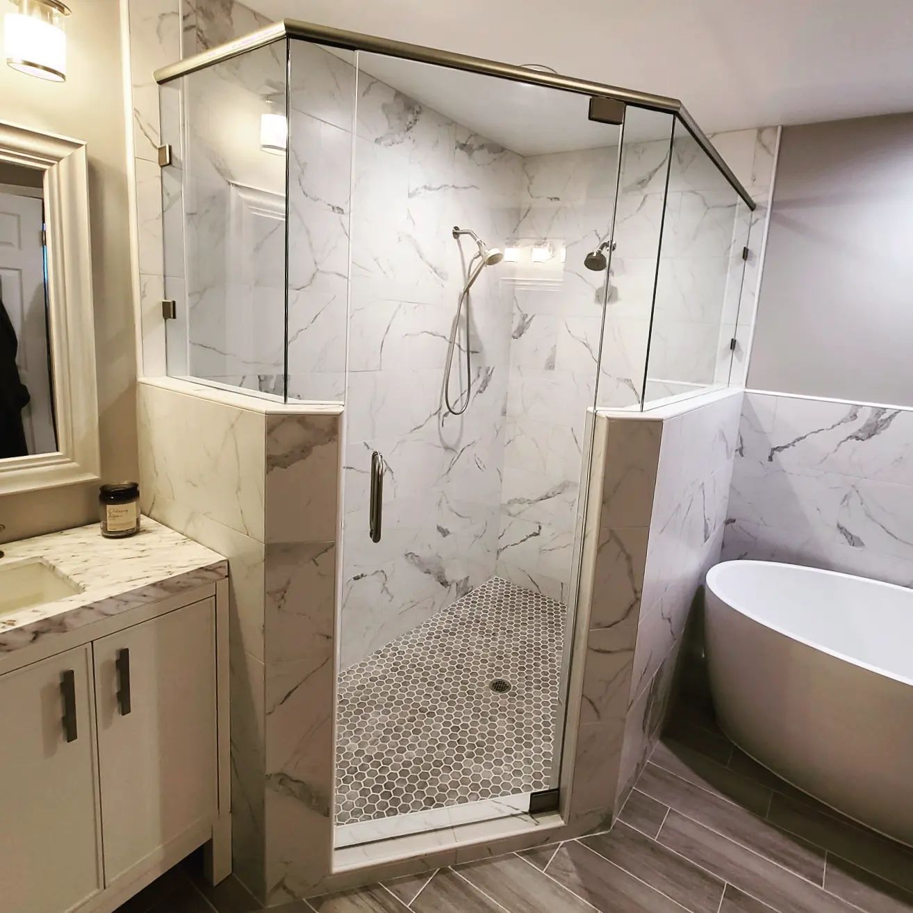 A bathroom with a walk in shower , tub , sink and mirror.