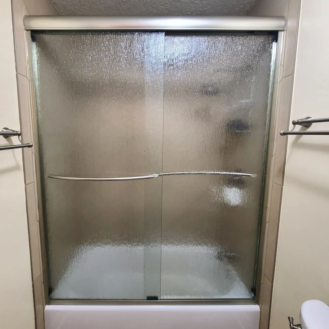 A bathroom with a bathtub and a shower stall with sliding glass doors.