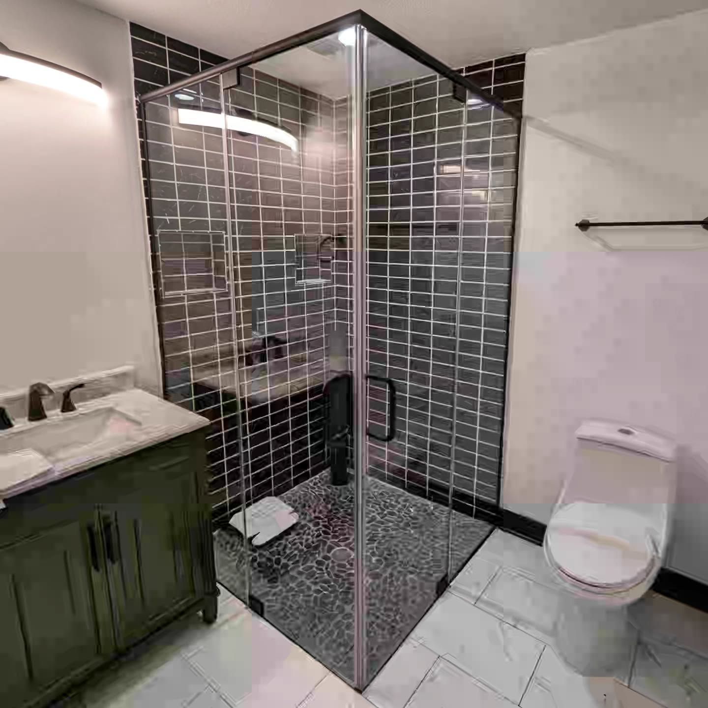 A bathroom with a toilet , sink and shower stall.