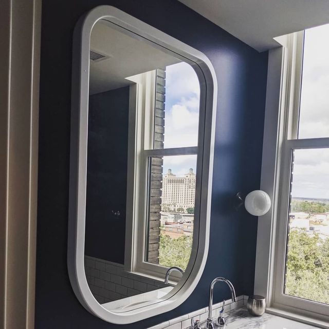 A bathroom with a large mirror and a window