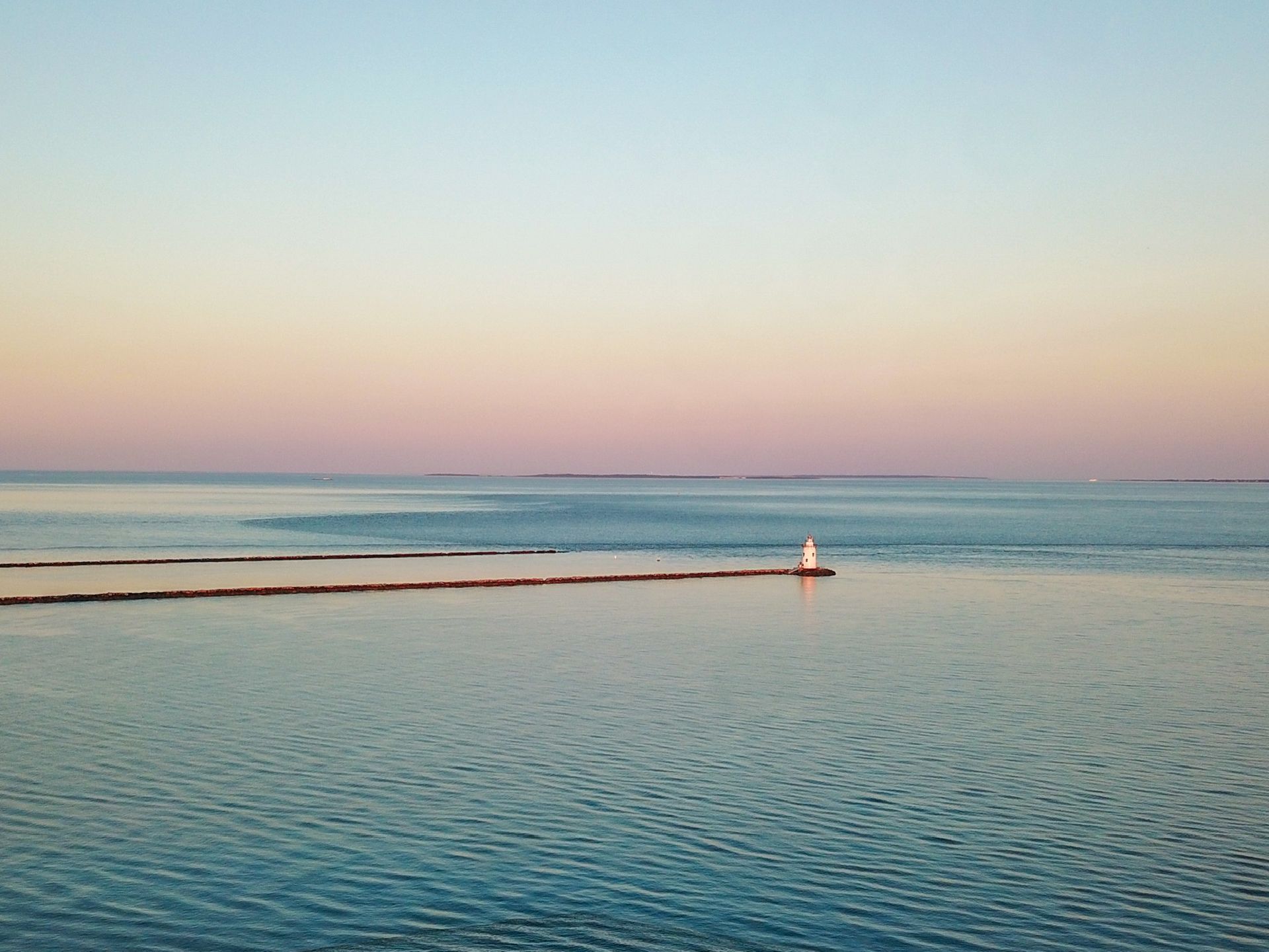 A large body of water with a lighthouse in the distance