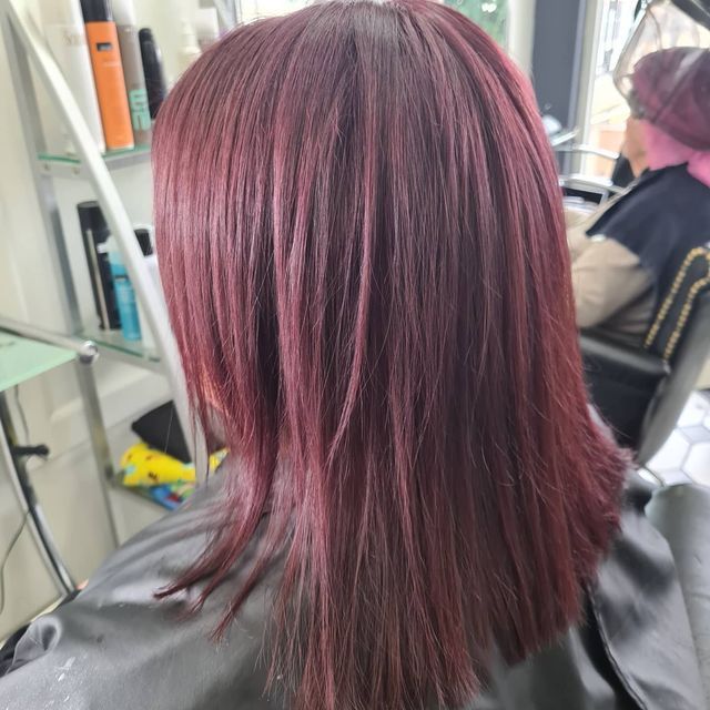 A Woman With Purple Hair is Sitting in a Chair in a Salon — Lush Hair Studio in Tumbi Umbi, NSW