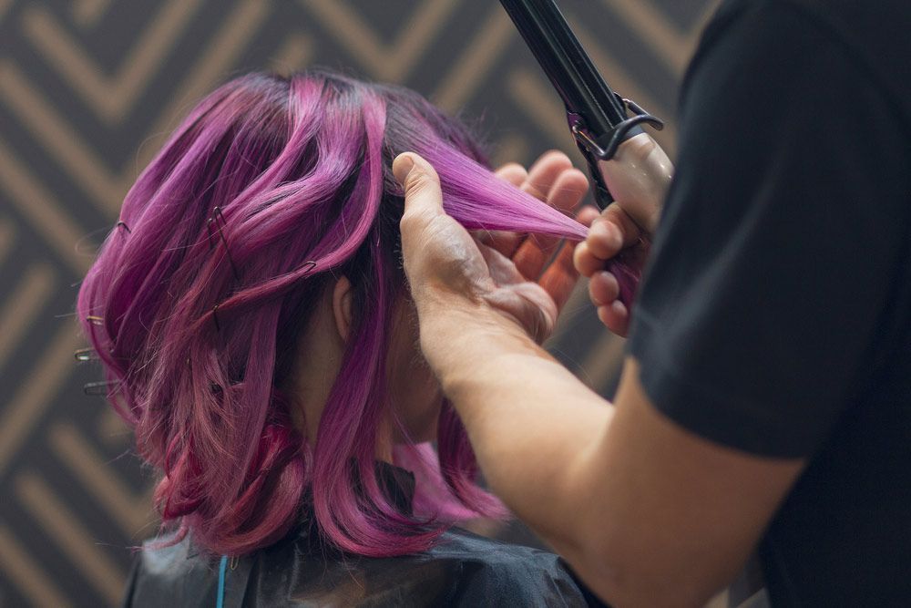 A Woman With Purple Hair is Getting Her Hair Done by a Hairdresser — Lush Hair Studio in Tumbi Umbi, NSW