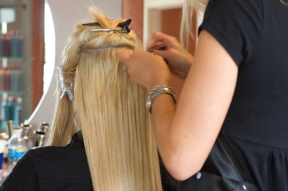 A Woman is Getting Her Hair Done by a Hairdresser in a Salon — Lush Hair Studio in Tumbi Umbi, NSW