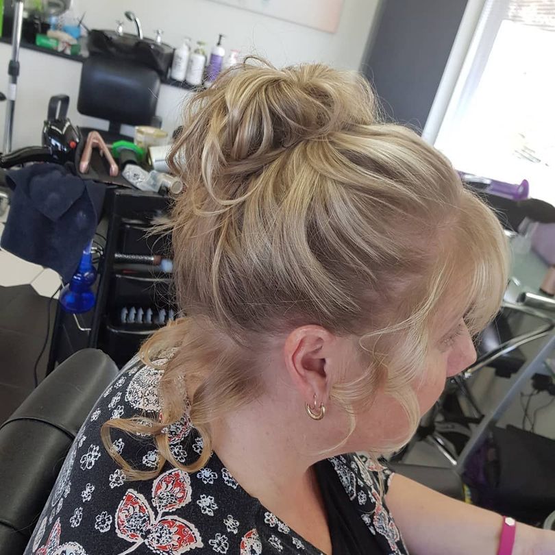 A Woman is Sitting in a Chair With Her Hair in a Bun — Lush Hair Studio in Tumbi Umbi, NSW