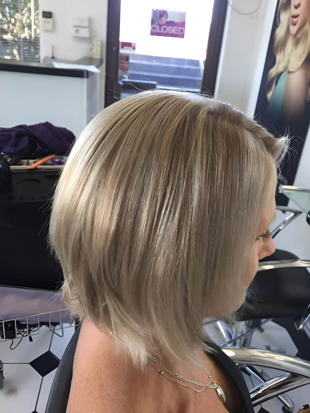 A Woman With Blonde Hair is Sitting in a Chair in a Salon — Lush Hair Studio in Tumbi Umbi, NSW