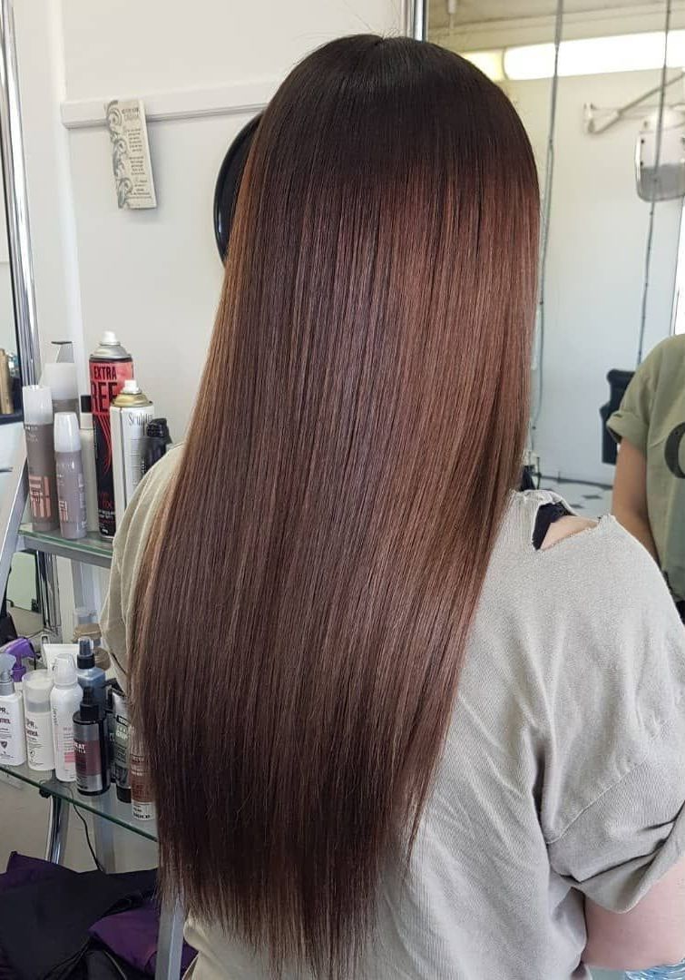 A Woman With Long Brown Hair is Standing in Front of a Mirror in a Salon — Lush Hair Studio in Tumbi Umbi, NSW